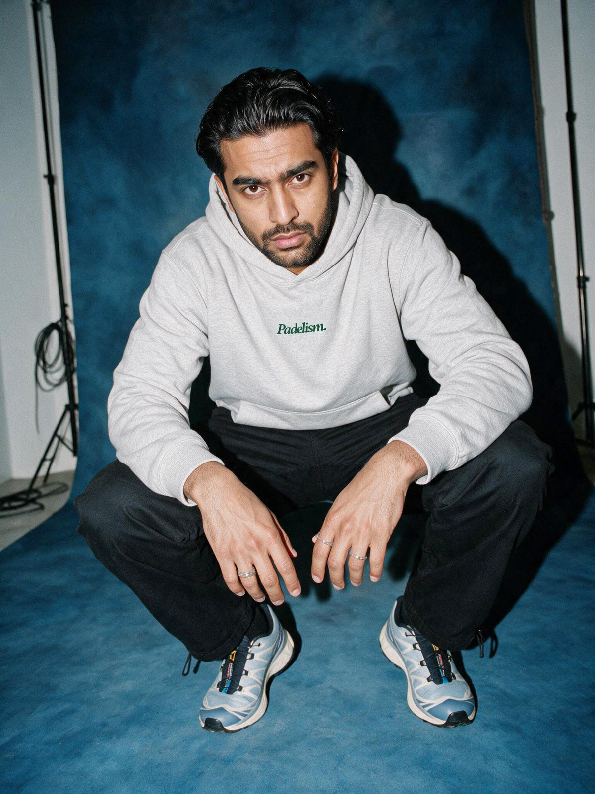 Model crouching in a Flower Gray Padelism Mk1 Box Hoodie